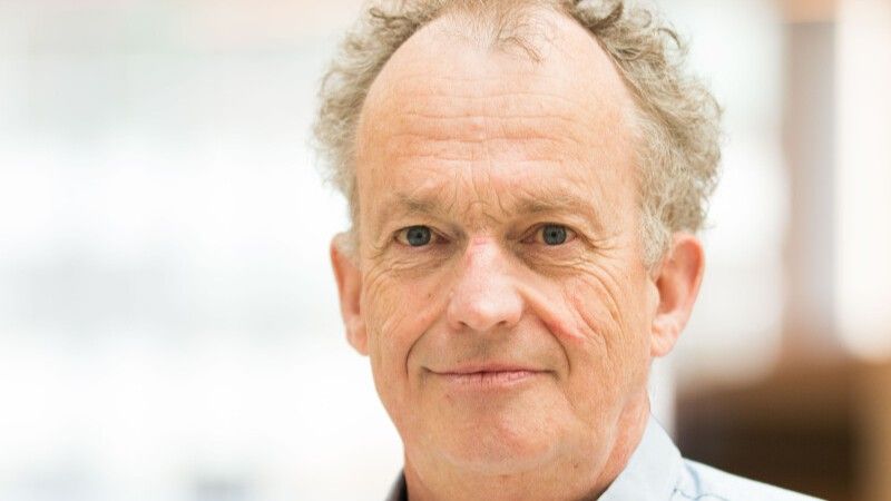 Porträtt av en person mot en ljus och oskarp bakgrund.