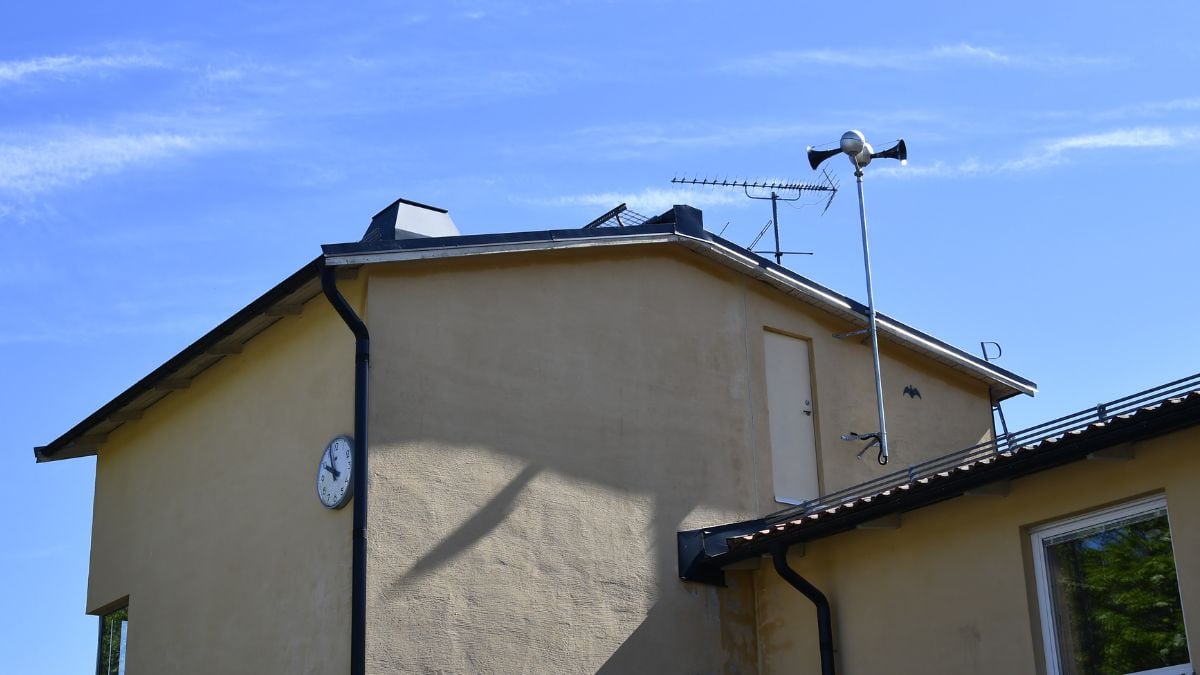 monterad på fasaden av en byggnad, sedd från marknivå mot himmel.