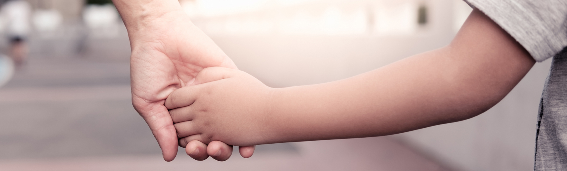 En vuxen håller ett barn i handen