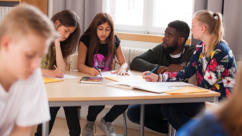 Lärare och elever i ett klassrum.