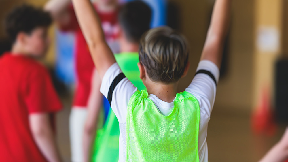 Barn i idrottskläder som spelar någon bollsport.