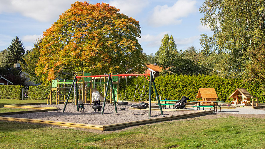 Lekplats med lekhus, gungor och sandlåda