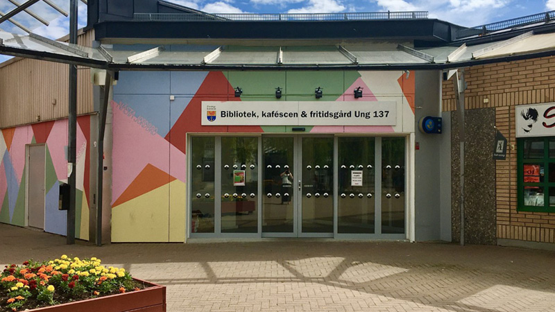 Fasaden på biblioteket i Jordbro, med blå himmel ovanför