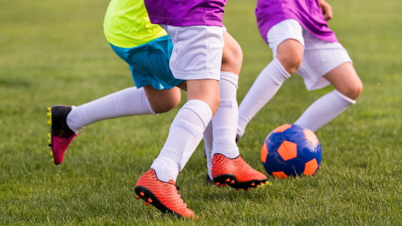 Barn som spelar fotboll.