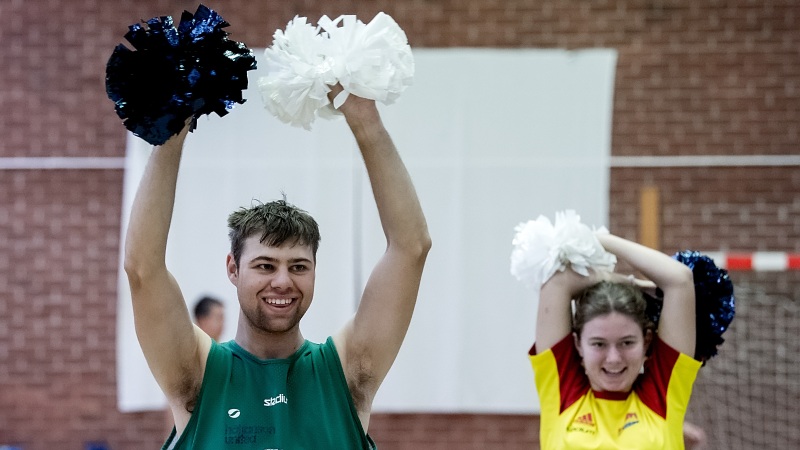 En kille och en tjej viftar med cheerleader-pompoms.